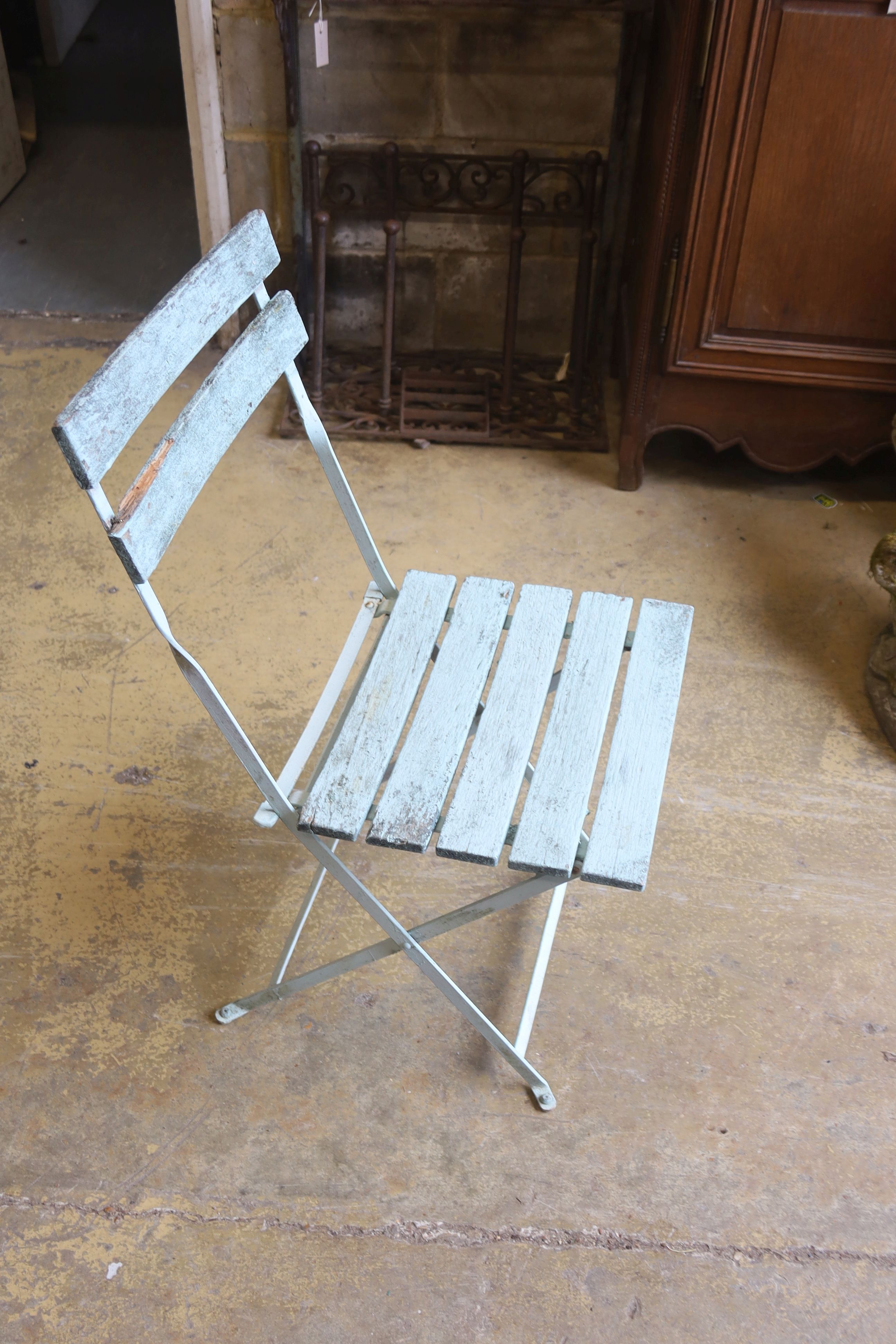 A set of four slatted metal folding garden chairs